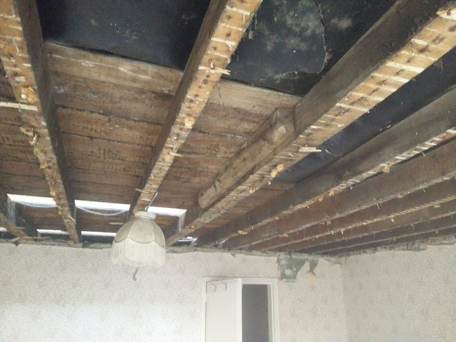 A ceiling taken down to the joists during a strip-out